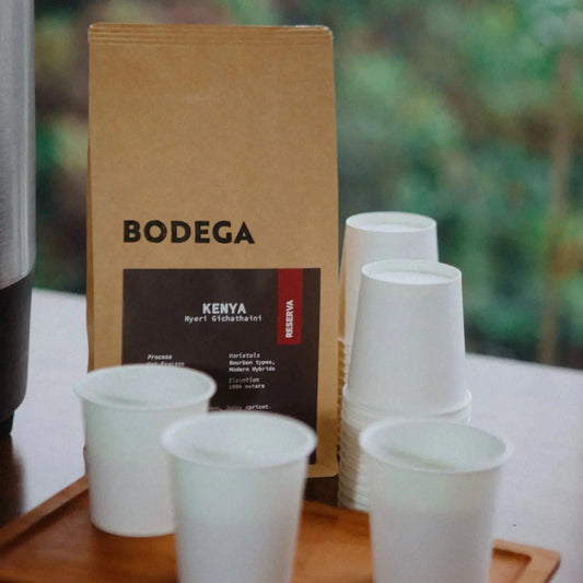 Bodega Kenya coffee package with white cups on a wooden tray