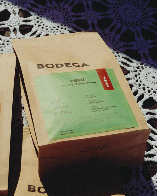 A bag of Peru coffee from Bodega Coffee Roasters, featuring minimalist packaging with origin details, set against a natural backdrop. - Bodega Coffee Roasters