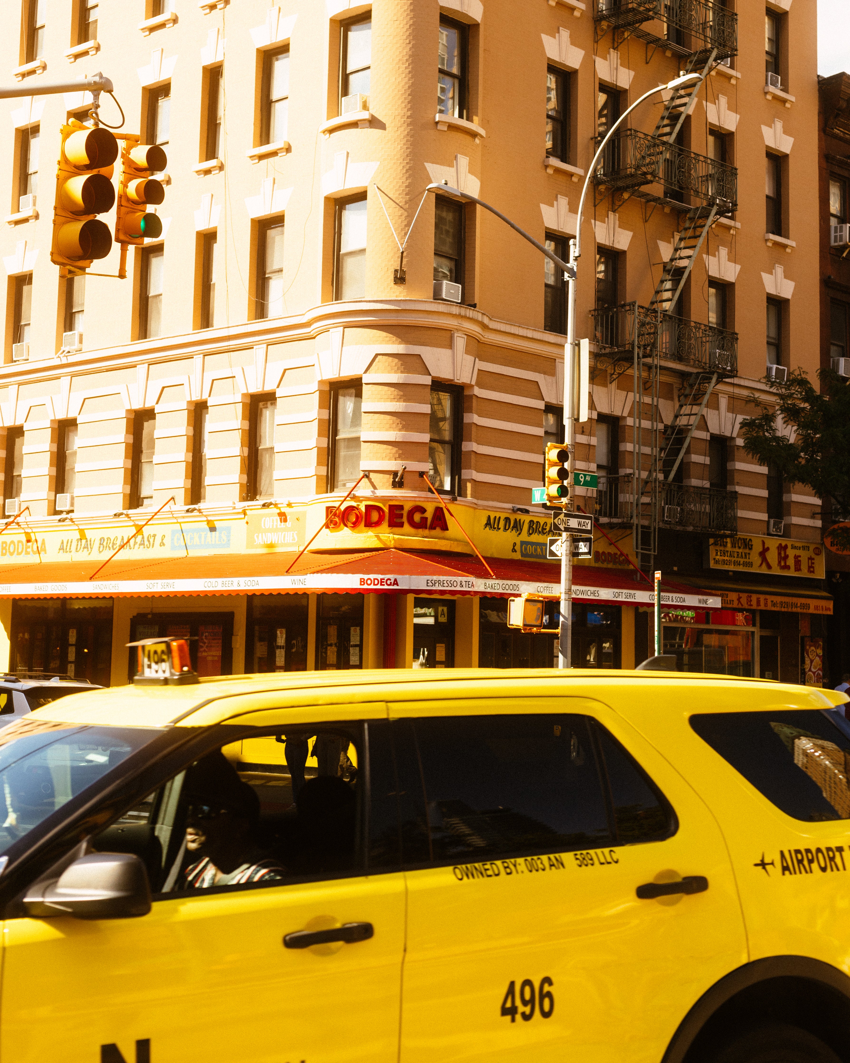 Taxi in front of a building which is in a corner that says BODEGA. - Bodega Coffee Roasters