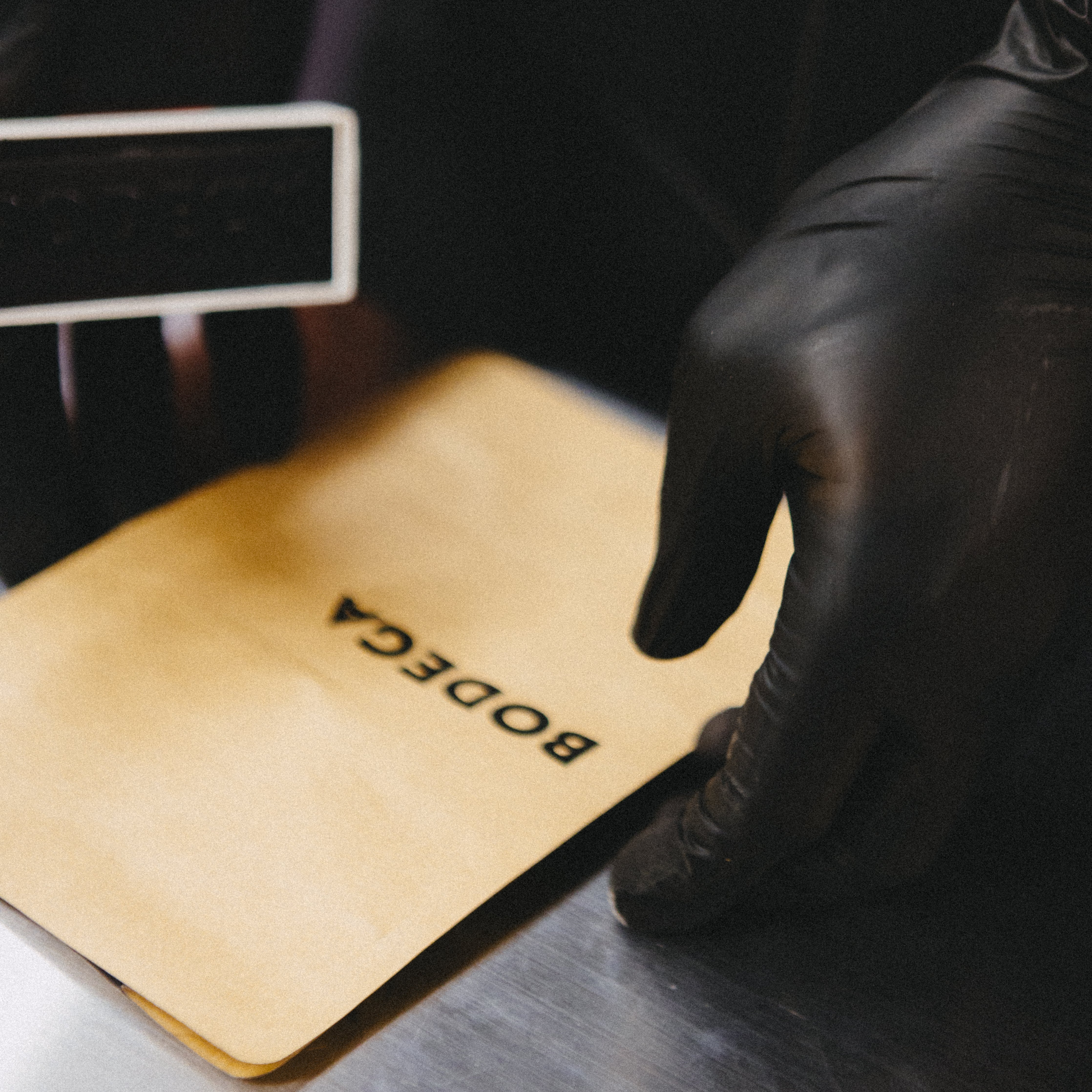 Coffee bag being stamped with the name bodega. -Bodega Coffee Roasters