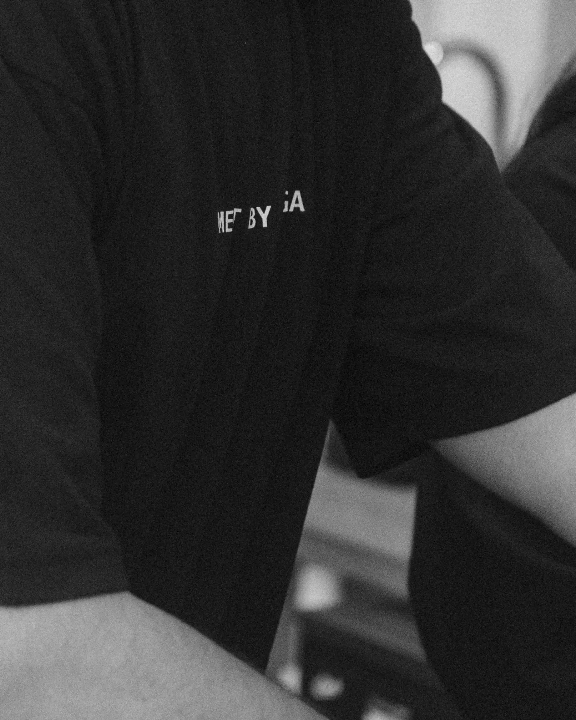 A close-up black short-sleeve t-shirt worn by a person, featuring the white text 'Element by Bodega' printed on the chest.